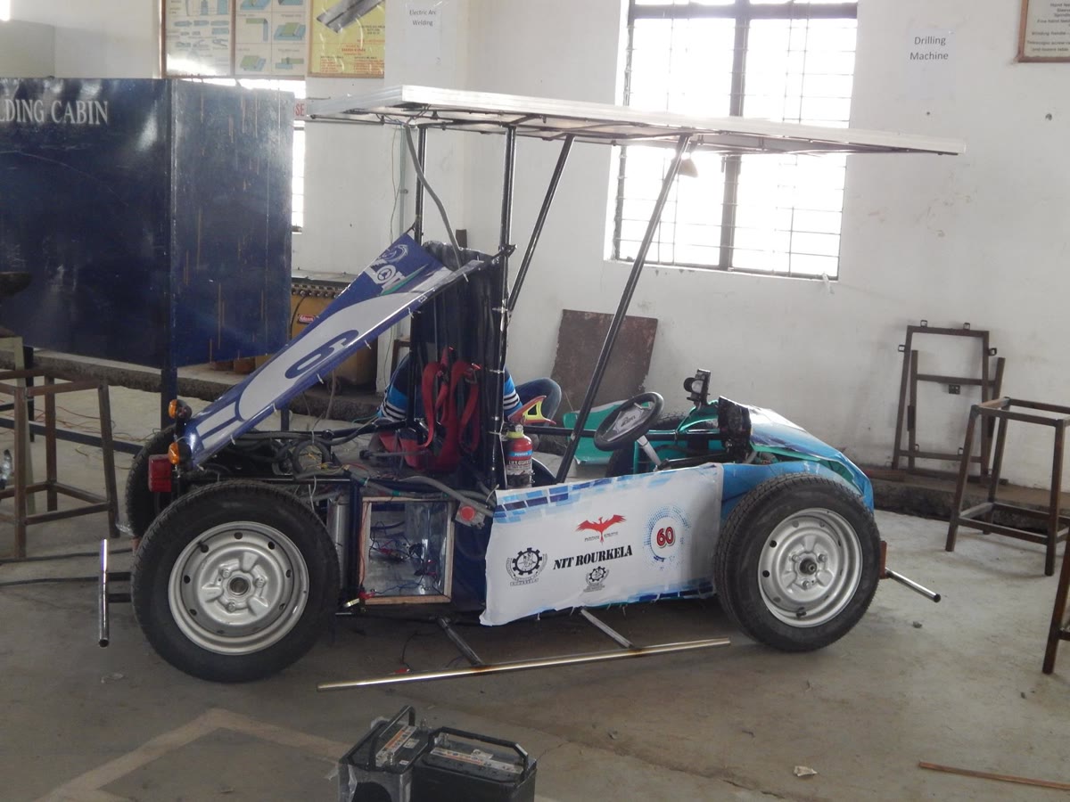 Team ZON's electric solar vehicle, with a solar canopy over an open tubular chassis, in a workshop